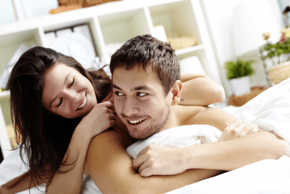 a woman in bed with a man who increased his dick with a nozzle